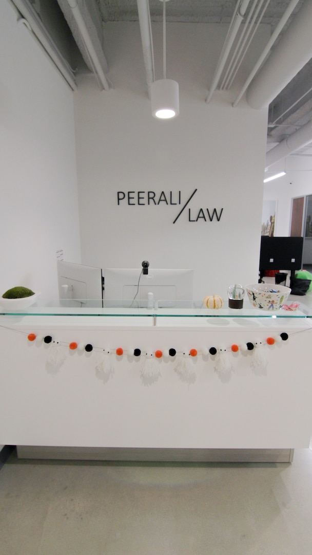 Reception desk at Peerali Law with firm logo behind, Hollywood Hills, Los Angeles